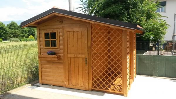 FOTO 4 casetta base cm 200x200 con aggiunta di : tettoia laterale con pavimento, chiusura lati tettoia con grigliato rombo, copertura tetto in coppo roofy, grondaie, cornici tetto tirolesi, fioriea,